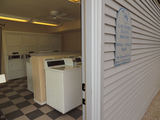 Pier Landing look into laundry facility with washer and dryers, pay with quarters, sign out front