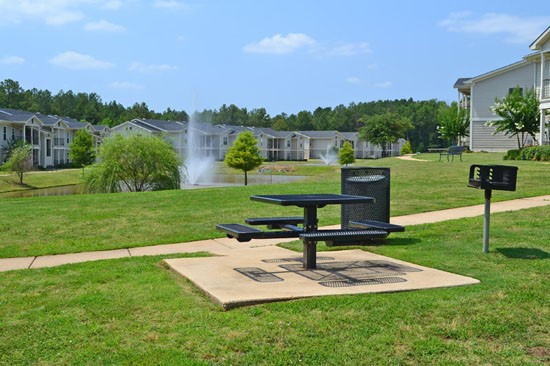 Westlake Apartments picnic table and benches, with trash can and grill next to lake
