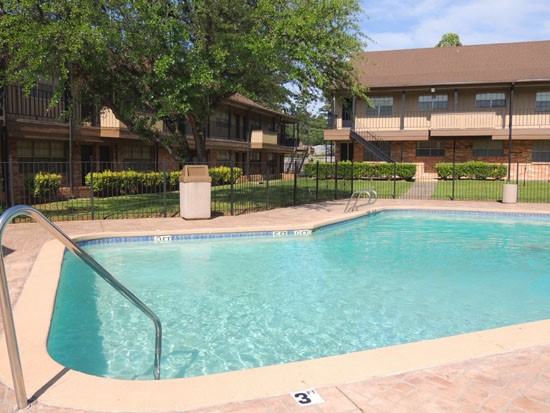 Castlewood Apartments Side View of Pool with Apartment Buildings in Back in Shreveport