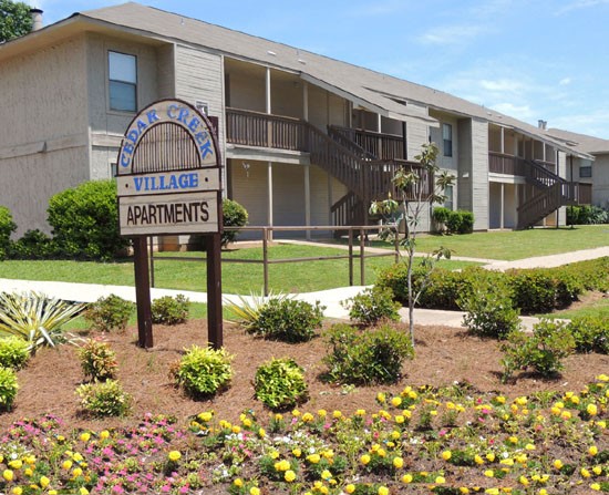 Cedar Creek Apartments Front Sign Surrounded by Scenery