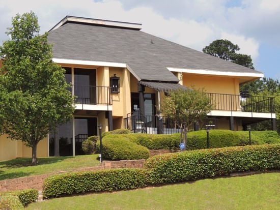 Chimney Hill Front Side View Of  Yellow Clubhouse with a Wrapped Around Balcony