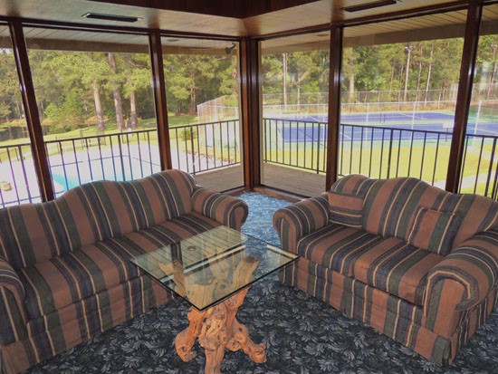 Chimney Hill Clubhouse Living Area With Full Sized Windows Looking out to Pool and Tennis Court