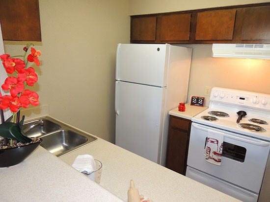 Cornerstone Apartments model kitchen with dark wood cabinets and kitchen appliances