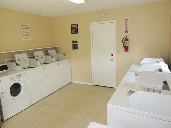 Heritage Village Apartments interior of laundry facility with laundry appliances pay with quarters