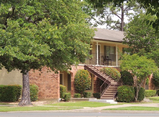 Kingston Village Apartments far side view of apartment buildings, trees blocking buildings