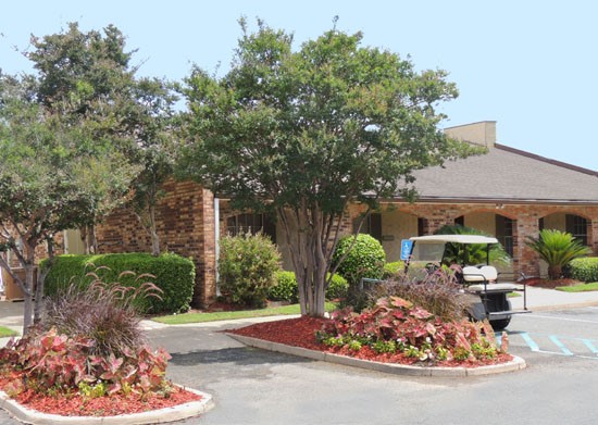 Kingston Village Apartments far side view of stunning front office building with parking lot