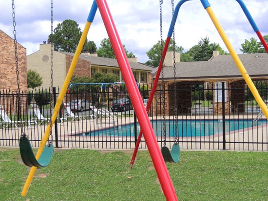 Kingston Oaks multi colored swing set right next to gated pool