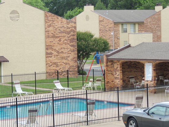 Kingston Village far away view of big gated pool with apartment buildings in back