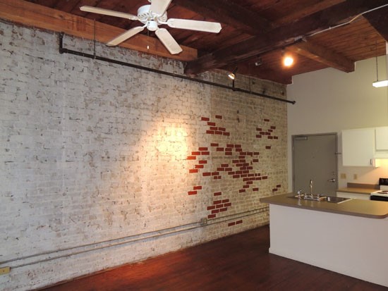 Lee Hardware Apartments looking into kitchen from open living room, cool wall