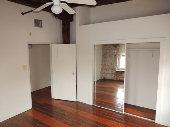 Lee Hardware Apartments model of big tall ceilings of master bedroom, with mirror on closet door