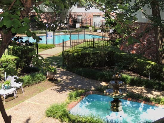 Park Villa front water fountain entering into gated pool area with lots of shade