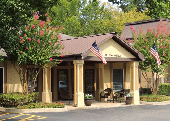 Riverbend Apartments Tan and Brown front office buildings with two american flags