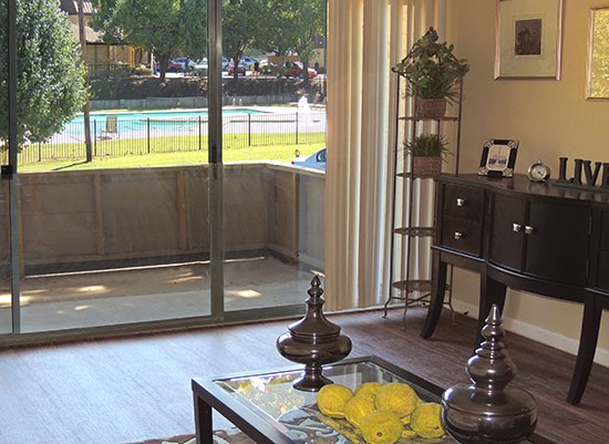 Riverbend model living room looking out back sliding door onto patio, overlooking pool area