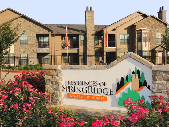 Springridge Apartments beautiful front sign with a picture surrounded by pink flowers