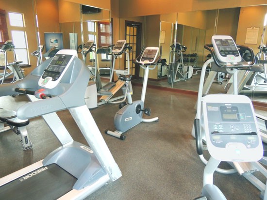 Springridge Apartments interior of fitness center with lots of equipment and mirror wall