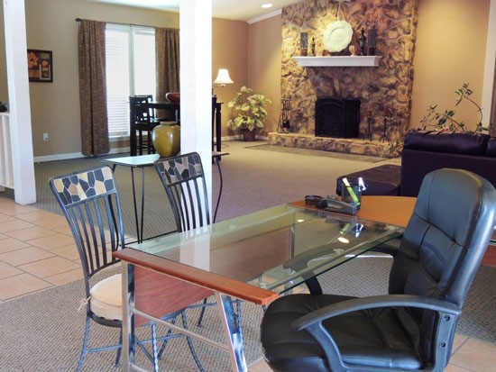 Tree Tops Apartments interior of open clubhouse with tables and chairs, with a brick  fireplace
