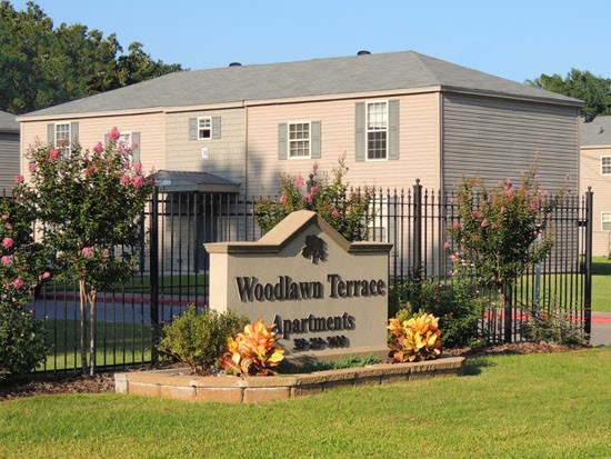 Woodland Terrance Apartments tan and brown sign in front fence in Shreveport Sign