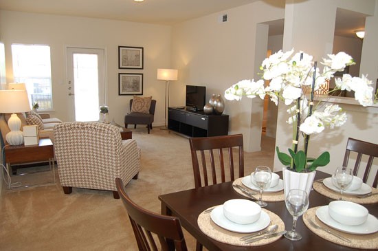 Westlake Apartments model dining room area looking into open living room area